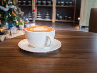 Delicious hot coffee in white cup on wooden table