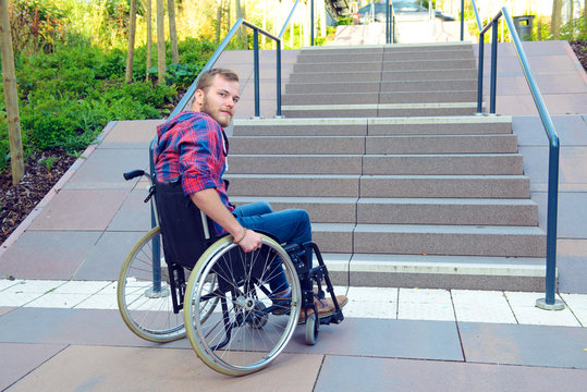 disabled man in wheelchair in front of stairs