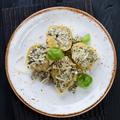 Plate with cheese and spinach stuffed conchiglione, top view