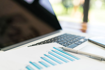 Financial charts on the table with laptop .