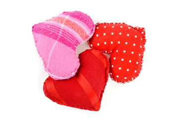 intertwined hearts made by hand from different tissues on a white background