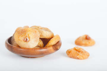 Dried figs in wooden bowl on white background