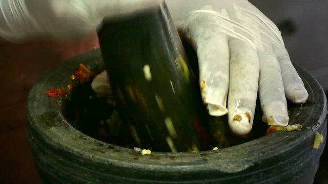 4K footage, close up hand pounding spices in stone mortar.