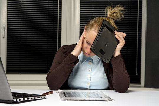 Girl Experiencing A Headache At Work, Blocking The Face With A C