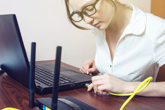 woman connect Internet cable to connector on the laptop