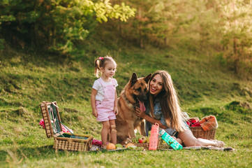 mother and daughter at a picnic with a dog