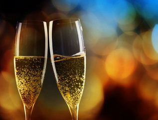 toasting with champagne glasses against holiday lights