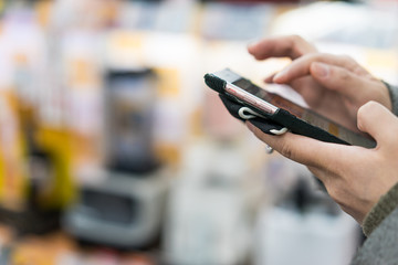 Female shopper using mobile phone during shopping
