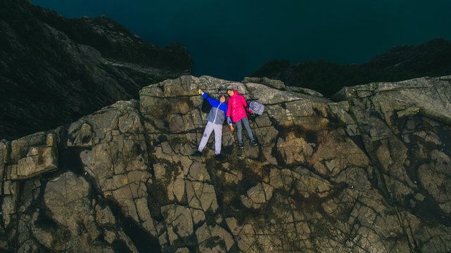 young couple lying on the edge of a cliff. Cliff Preikestolen in