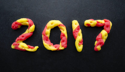 Happy holidays card with red and yellow color plasticine figures 2017.