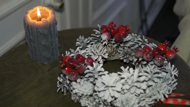 Christmas wreath and burning candle on the table. Soon holiday