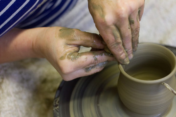closeup of hands working on pottery wheel, clay pot 