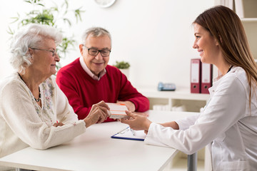 Obraz premium Doctor giving drugs to her senior woman patient
