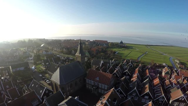Aerial of Marken flying backwards away from typical Dutch village it forms a peninsula in Markermeer and was formerly an island in Zuiderzee characteristic wooden houses are a tourist attraction 4k
