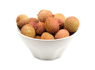 Many ripe litchi fruits isolated in white bowl front view closeup