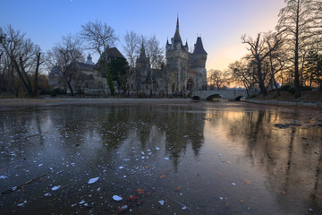 The reflection of Vajdahunyad Castle on the frozen lake at Budapest, Hungary during evening in cold winter season