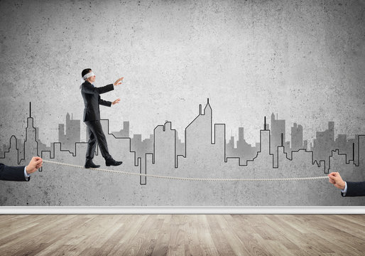 Business concept of risk support and assistance with man balancing on rope