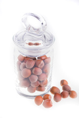 Hazelnuts in glass jar on a white background. Isolated. Dried nuts.