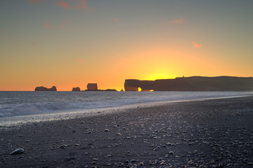 Sunset at Kirkjufjara beach and Dyrholaey rock