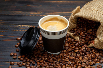 cup of coffee and beans on wooden background