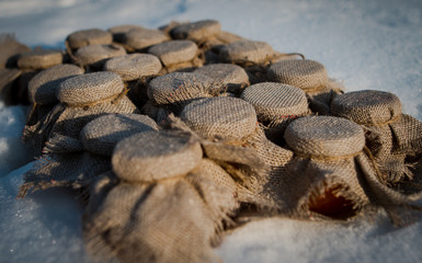 Jars with mandarin jam on a snow covered with burlap cover