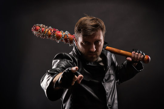  Killer with bloody bat on black background.