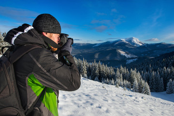 Fototapeta na wymiar Photographer in snow mountains