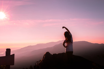 The silhouette of a woman in a yoga pose on the mountain at the Sunset.