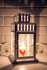 Lantern for candles with burning candle in darkness.