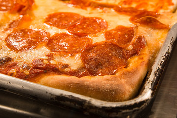 Delicious authentic New York style Sicilian pizza with pepperoni in pan 