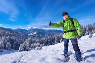 Fototapeta na wymiar Tourist in winter mountains success, everything is OK!