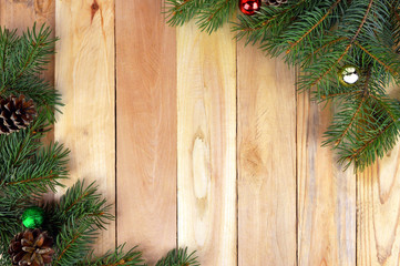 Fototapeta na wymiar Christmas wooden background with Christmas tree and pine cones.