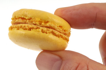 Macaron au citron tenu en main