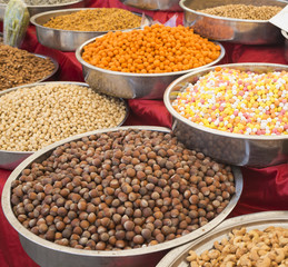 Obraz premium A variety of nuts in the glaze: peanuts, hazelnuts, chestnuts, walnuts, pistachio and pecans. Food and cuisine. (Selective focus)