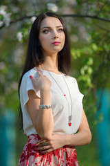 Beautiful yong model wearing luxury jewelry in blooming spring 