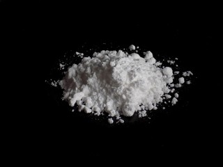 Fototapeta na wymiar Cocaine drug powder pile on black background