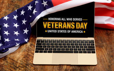 Thank you veterans written in laptop with flag of the United States, on a rustic wooden background