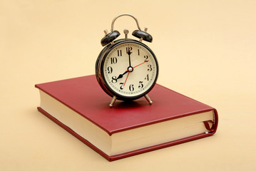 Alarm Clock on Book with study supplies in background