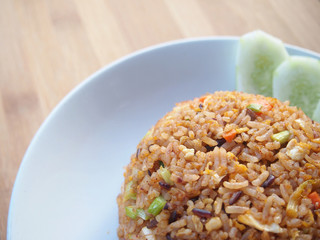 Fried Rice with Chicken, Cucumber and Parsley on White Dish ,Wood Table , Thai Cuisine