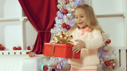 Cute girl jumping from happiness getting a gift for the new year