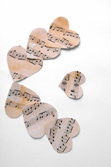 Paper hearts with music notes on white background