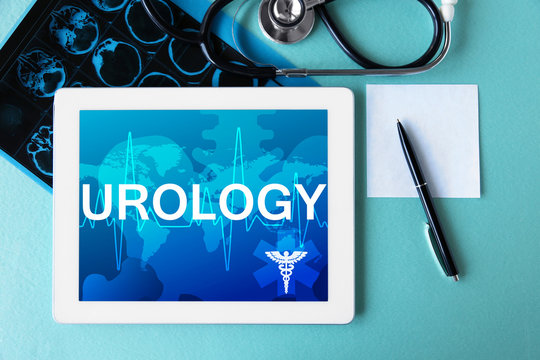 Tablet on color background. Word UROLOGY on screen. Health care concept.