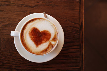 Cup with hot tasty coffee on wooden table, close up view