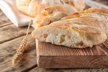Sliced baguette bread on wooden cutting board closeup