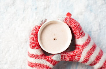 female hands in gloves holding hot chocolate