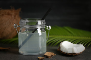Fototapeta na wymiar Mason jar with coconut water and fresh nuts on dark background