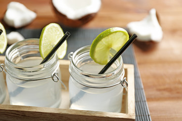 Set of mason jars with coconut water decorated with lime