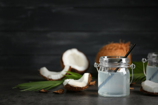 Mason jar with coconut water and fresh nuts on dark background