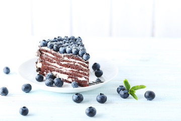 Tasty piece of cake with blueberries on wooden table
