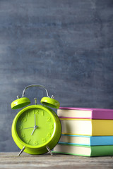 Green alarm clock on a grey wooden table